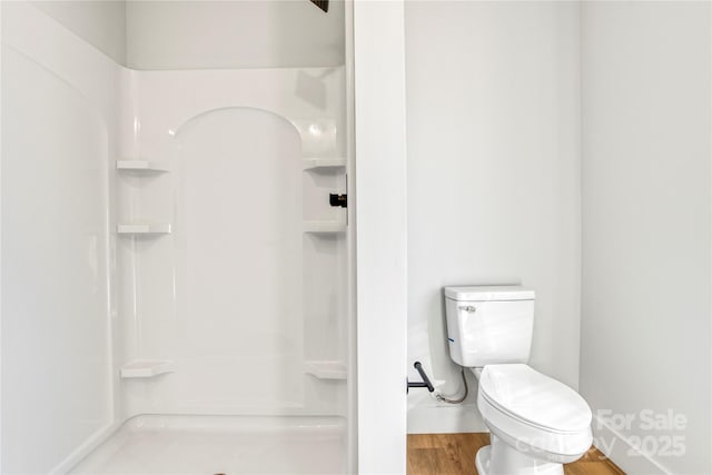 full bathroom featuring toilet, wood finished floors, and a walk in shower