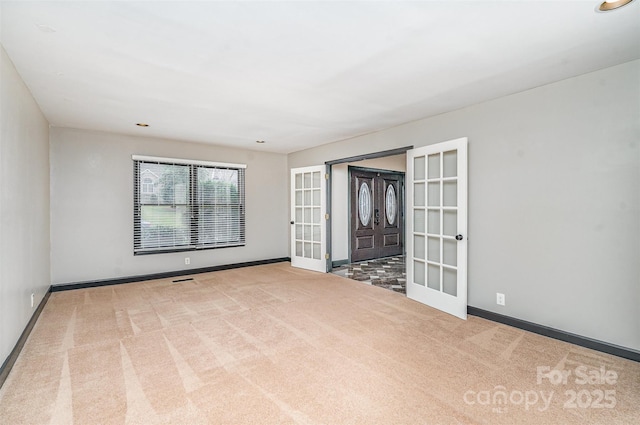 spare room with french doors, baseboards, and carpet flooring