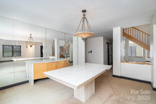 kitchen featuring hanging light fixtures, a large island, light countertops, modern cabinets, and open floor plan