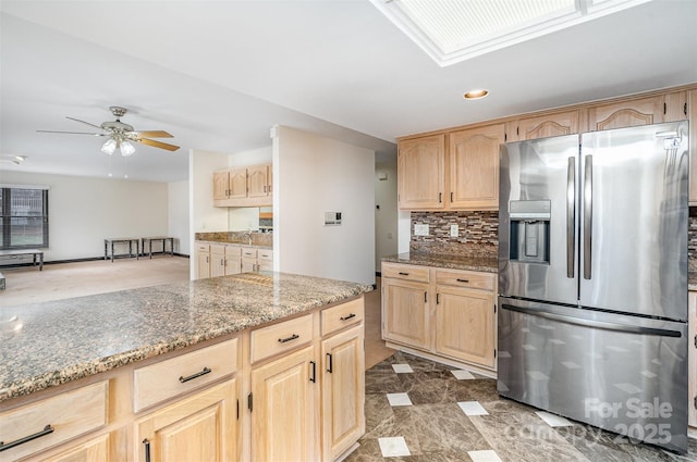 kitchen featuring a ceiling fan, light stone countertops, light brown cabinetry, decorative backsplash, and stainless steel refrigerator with ice dispenser