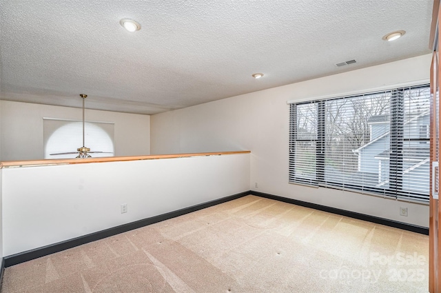 unfurnished room featuring visible vents, carpet floors, and plenty of natural light