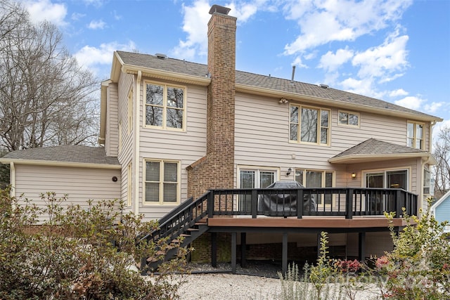 rear view of house featuring a wooden deck, a chimney, and stairs