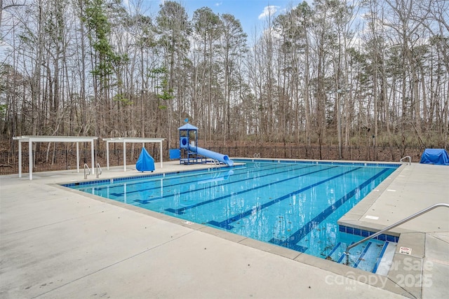 pool with a water slide and a patio