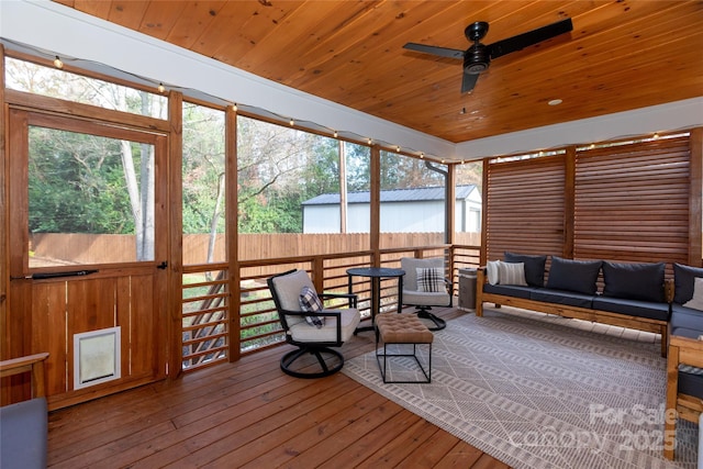 sunroom / solarium with a wealth of natural light, wooden ceiling, and a ceiling fan