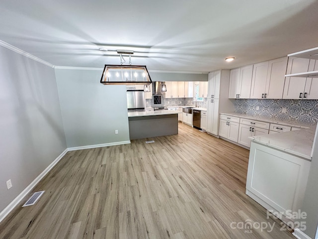 7812 Highbanks Ct, Charlotte, NC 28212 - kitchen with decorative backsplash, visible vents, light wood-style flooring, crown molding, and stainless steel appliances