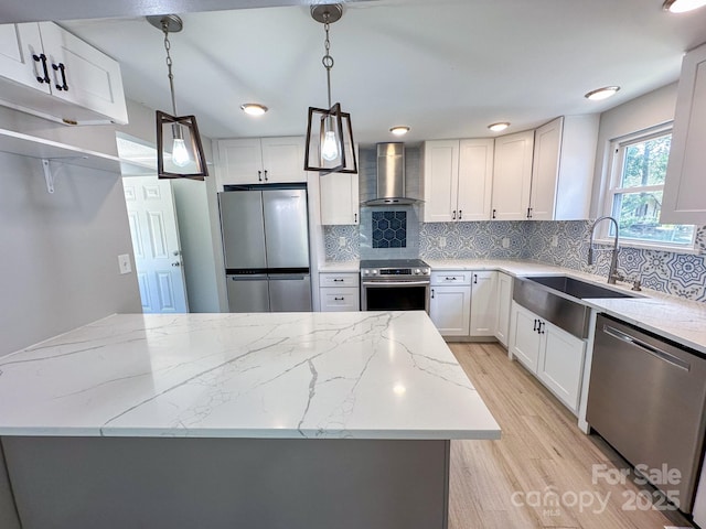 7812 Highbanks Ct, Charlotte, NC 28212 - kitchen featuring tasteful backsplash, light wood-type flooring, a sink, appliances with stainless steel finishes, and wall chimney exhaust hood