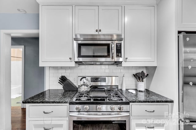 kitchen with stainless steel appliances, white cabinets, and decorative backsplash