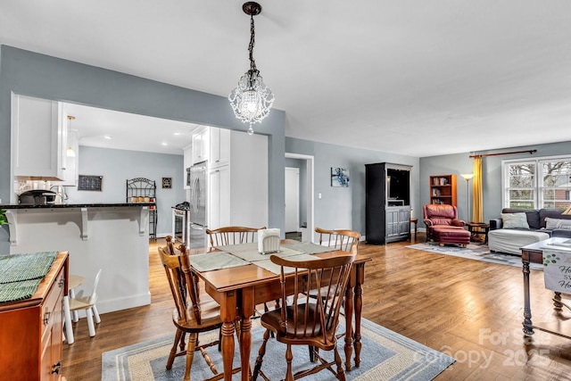 dining area with a notable chandelier and light wood finished floors