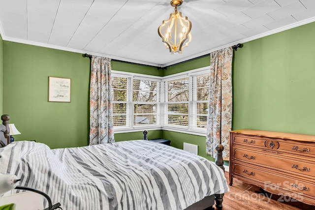 bedroom with crown molding, multiple windows, and wood finished floors