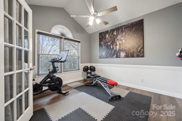 workout room featuring wood finished floors, baseboards, ceiling fan, vaulted ceiling, and french doors