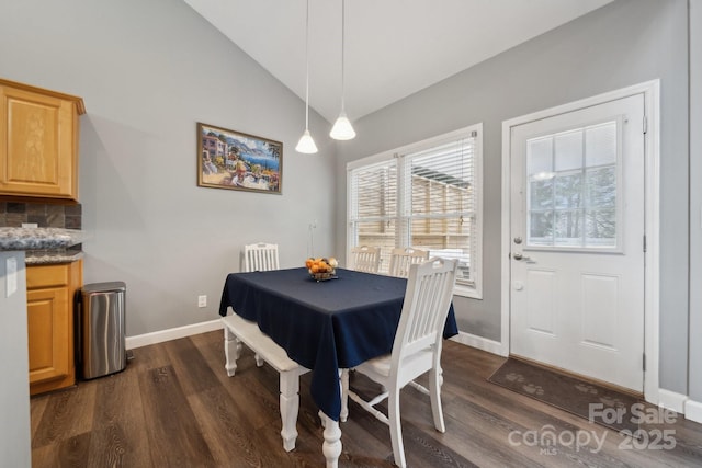 dining room with baseboards, dark wood finished floors, and vaulted ceiling