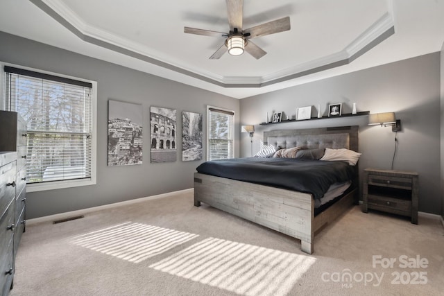 bedroom with a tray ceiling, visible vents, and ornamental molding