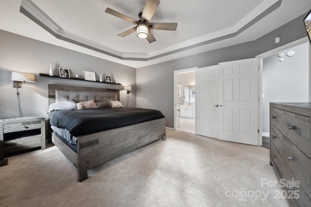 bedroom with connected bathroom, crown molding, ceiling fan, carpet floors, and a raised ceiling