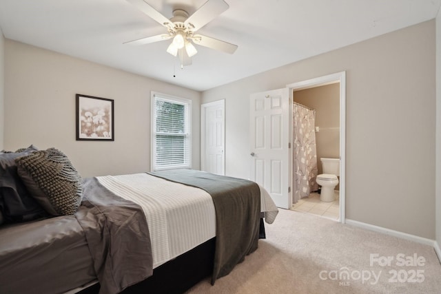 bedroom featuring connected bathroom, baseboards, ceiling fan, light colored carpet, and a closet