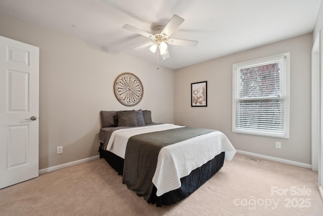 bedroom featuring a ceiling fan, visible vents, baseboards, and light carpet