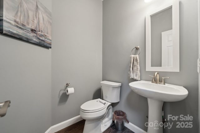 bathroom featuring baseboards and toilet