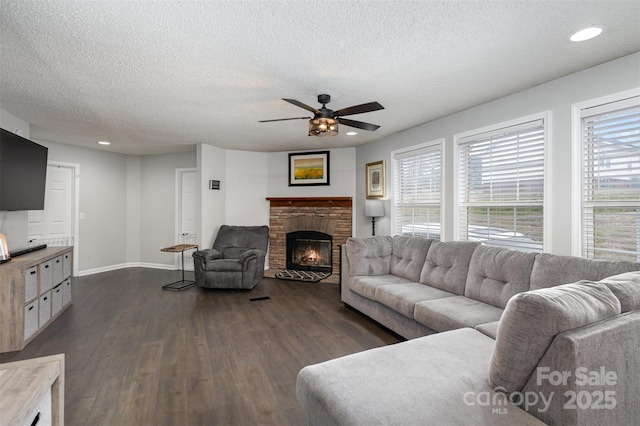 living area with a glass covered fireplace, dark wood-type flooring, recessed lighting, and a ceiling fan