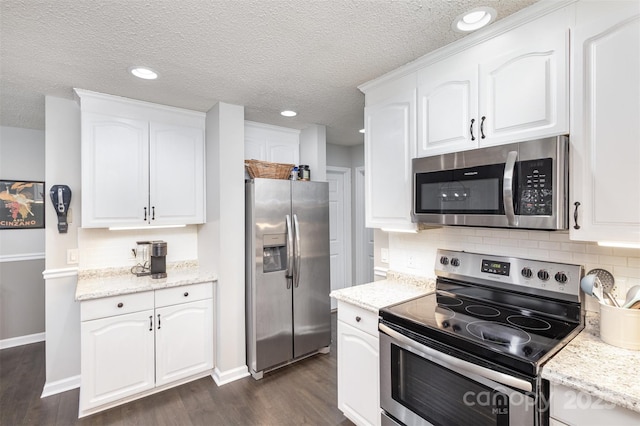 kitchen with white cabinetry, dark wood-type flooring, appliances with stainless steel finishes, and decorative backsplash