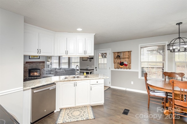 kitchen with visible vents, dark wood-type flooring, stainless steel dishwasher, white cabinets, and a sink