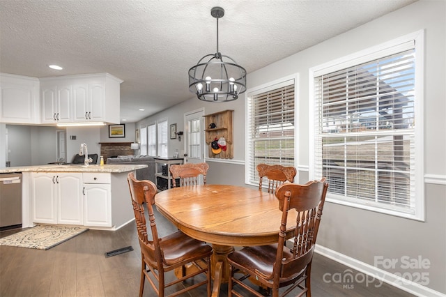 dining room with dark wood-style floors, visible vents, recessed lighting, a textured ceiling, and a notable chandelier