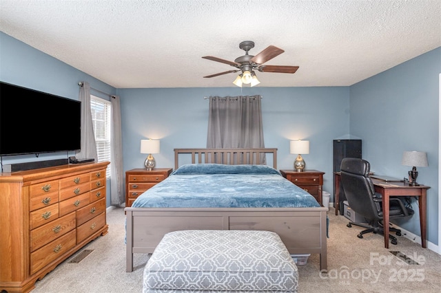 bedroom featuring light colored carpet, ceiling fan, and a textured ceiling