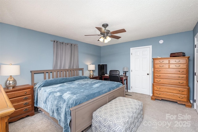 bedroom with a ceiling fan, light colored carpet, and a textured ceiling