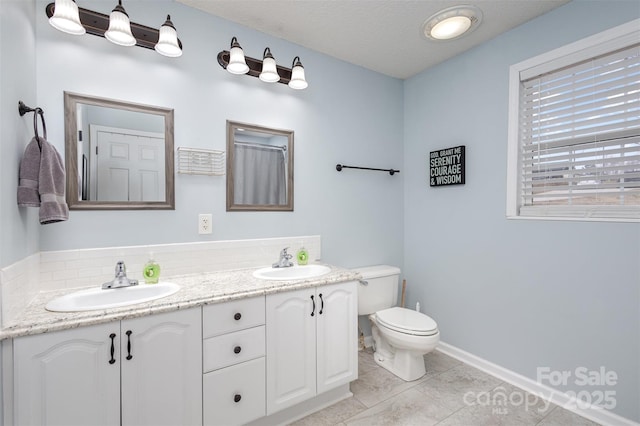 bathroom with a sink, decorative backsplash, toilet, and double vanity