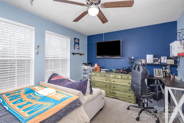 bedroom with a ceiling fan, carpet, and a textured ceiling