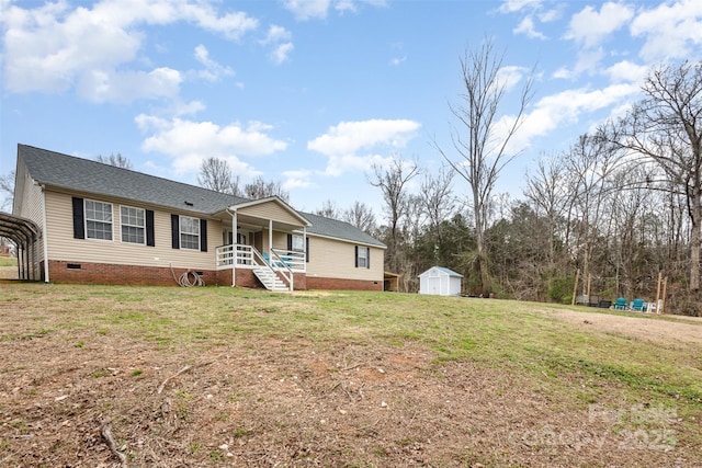 ranch-style home with a porch, a shed, an outdoor structure, a front yard, and crawl space