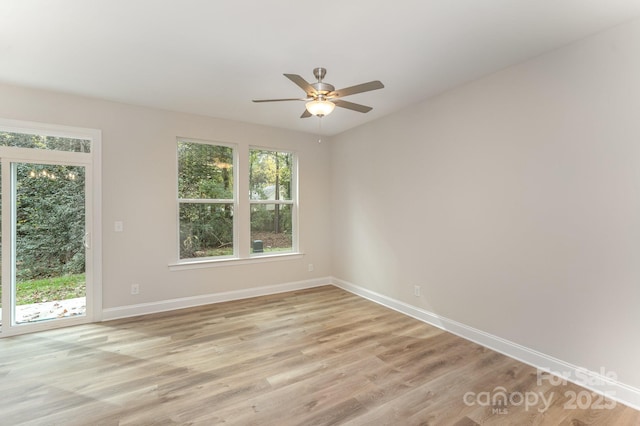 unfurnished room with a ceiling fan, baseboards, and light wood finished floors