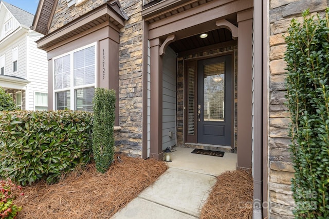 doorway to property featuring stone siding