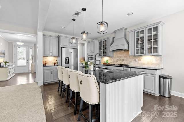 kitchen featuring visible vents, custom exhaust hood, gray cabinets, a sink, and stainless steel appliances