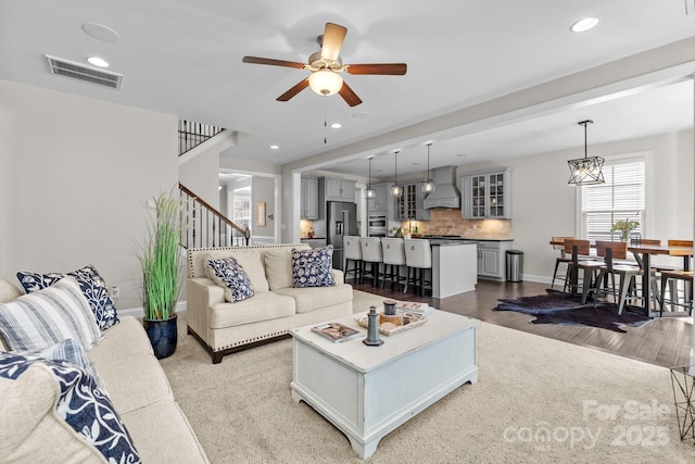 living room with visible vents, ceiling fan, stairway, recessed lighting, and wood finished floors