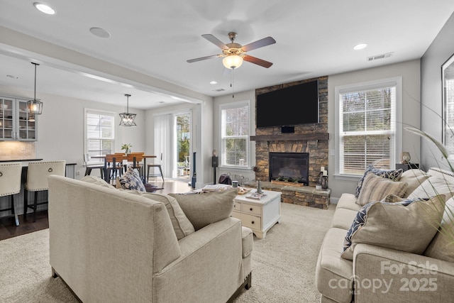 living room featuring recessed lighting, visible vents, ceiling fan, and a fireplace