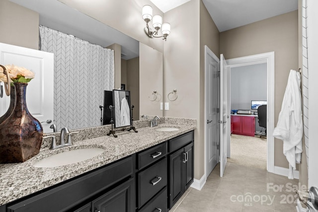 bathroom with tile patterned flooring, double vanity, baseboards, and a sink