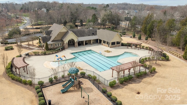 community pool featuring a patio, fence, and playground community