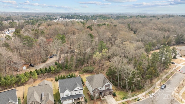 bird's eye view featuring a residential view and a wooded view