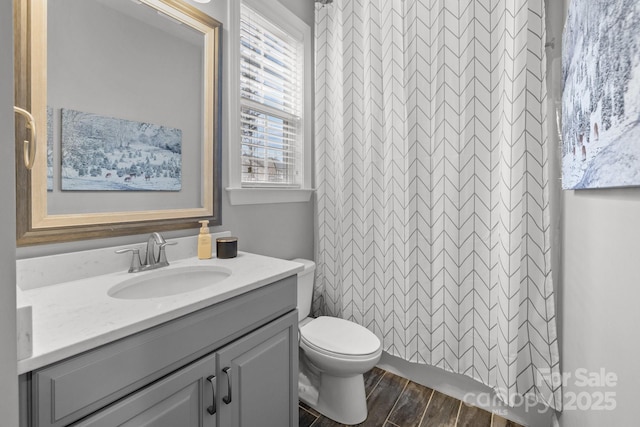 full bathroom with a shower with shower curtain, toilet, wood finished floors, and vanity