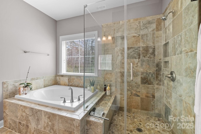 bathroom featuring a bath, visible vents, and a shower stall