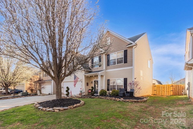 traditional-style home featuring a garage, concrete driveway, a front lawn, and fence