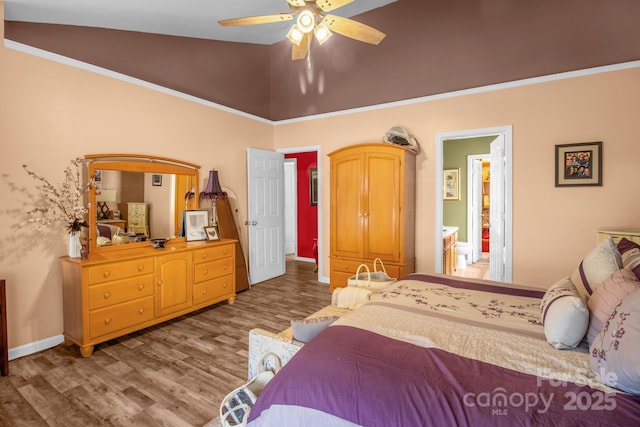 bedroom featuring connected bathroom, baseboards, ceiling fan, vaulted ceiling, and wood finished floors