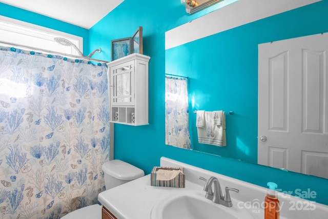 bathroom featuring curtained shower, toilet, and vanity