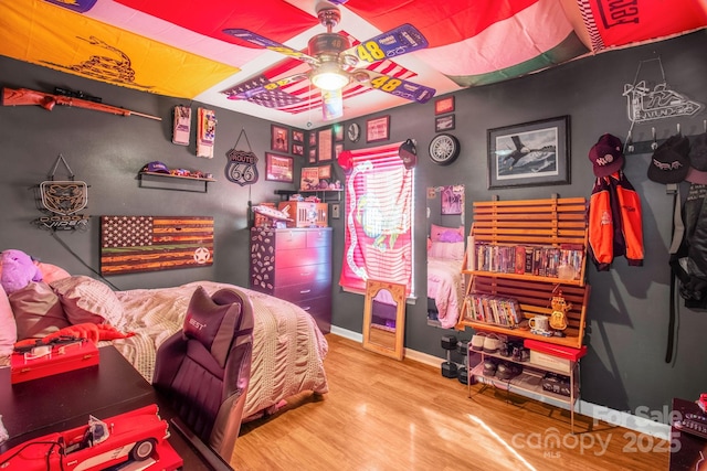 bedroom featuring wood finished floors, baseboards, and ceiling fan