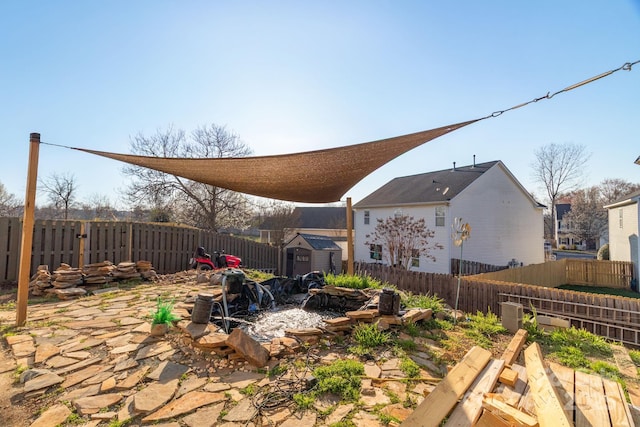 view of yard featuring an outbuilding, a storage unit, and a fenced backyard