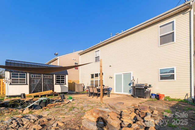 back of property with an outbuilding, cooling unit, and a patio