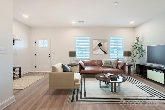 living room with visible vents, recessed lighting, baseboards, and wood finished floors