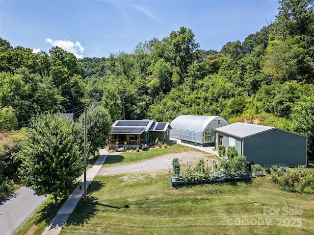 drone / aerial view with a wooded view