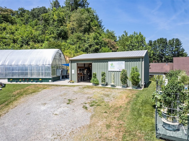 exterior space with an exterior structure, a lawn, and driveway