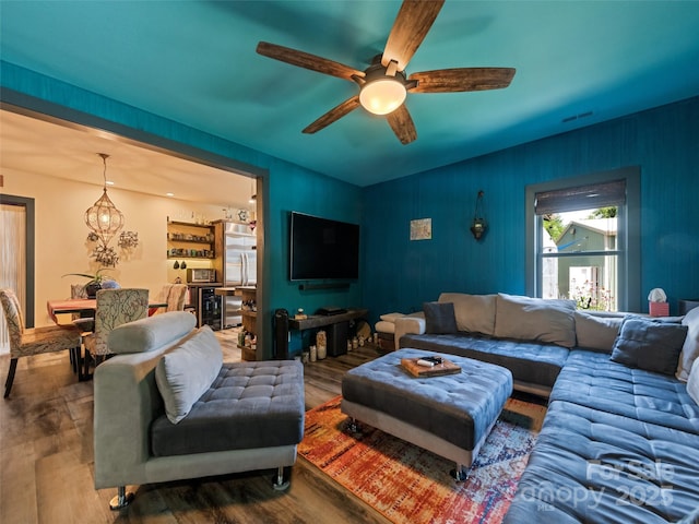 living area featuring visible vents, a ceiling fan, and wood finished floors