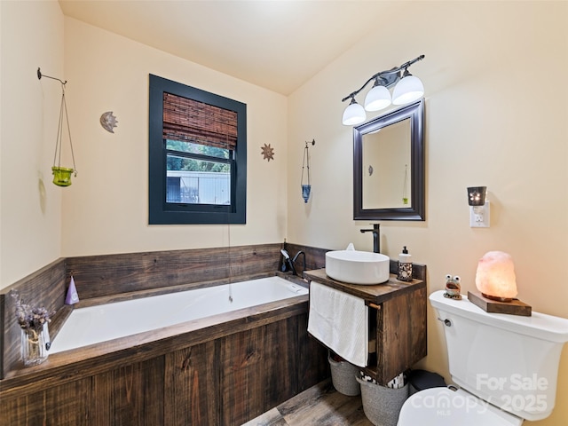 full bathroom featuring vanity, a garden tub, and toilet